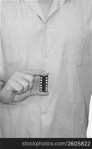 Mid section view of a male nurse holding two dices