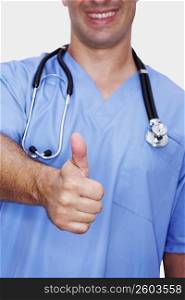 Mid section view of a male nurse making a thumbs up sign