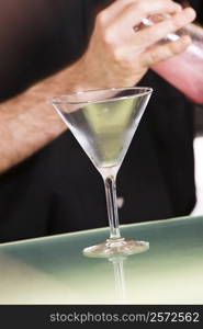Mid section view of a man holding a cocktail shaker