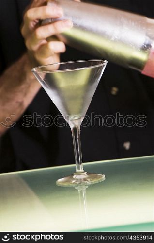 Mid section view of a man holding a cocktail shaker