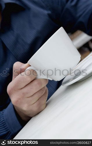 Mid section view of a man holding a cup of tea