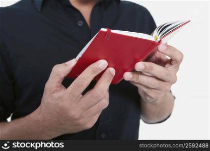 Mid section view of a man holding a diary
