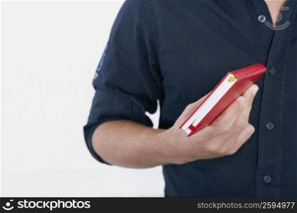 Mid section view of a man holding a diary
