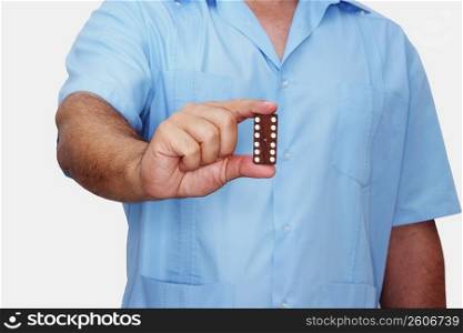Mid section view of a man holding a domino