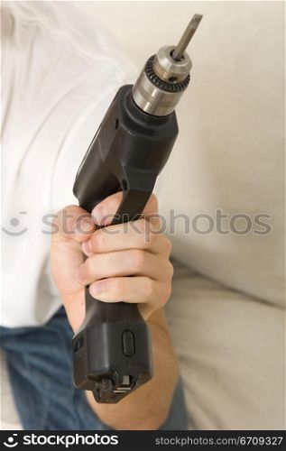 Mid section view of a man holding a drill