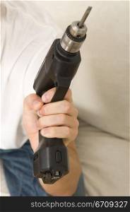 Mid section view of a man holding a drill