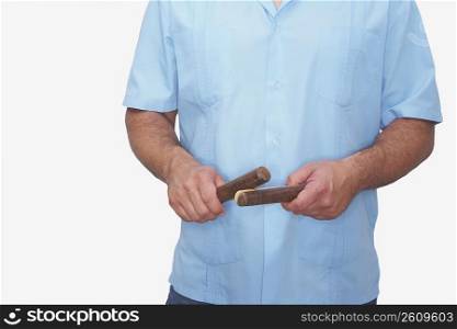 Mid section view of a man holding a pair of claves
