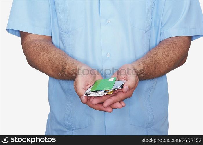 Mid section view of a man holding various types of credit cards