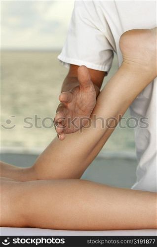 Mid section view of a man massaging a woman&acute;s leg