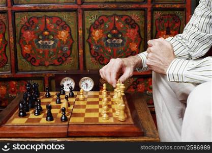 Mid section view of a man playing chess