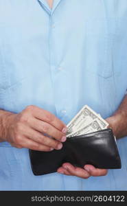 Mid section view of a man taking out money from a wallet