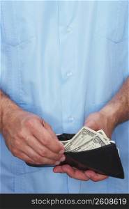 Mid section view of a man taking out money from a wallet