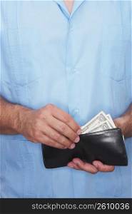 Mid section view of a man taking out money from a wallet