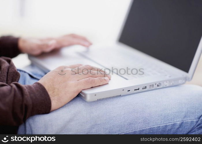 Mid section view of a man using a laptop