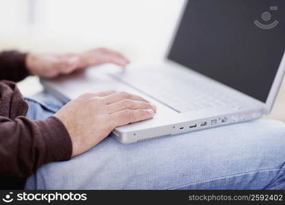 Mid section view of a man using a laptop