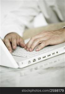 Mid section view of a man using a laptop