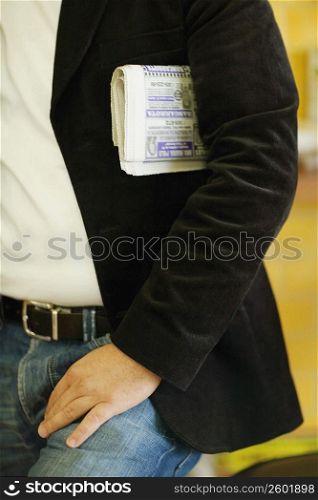 Mid section view of a man with a newspaper