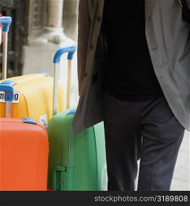 Mid section view of a man with suitcases