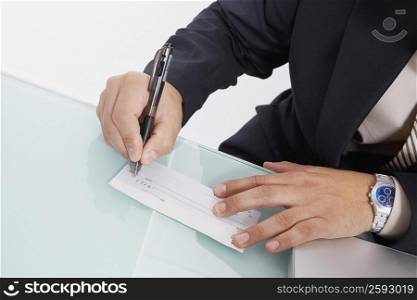 Mid section view of a man writing a check