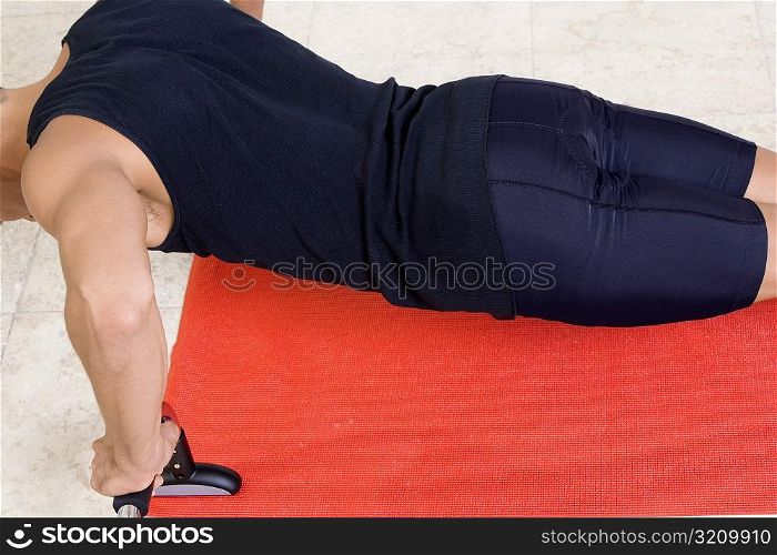 Mid section view of a mid adult man doing push-ups