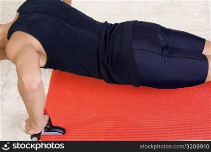 Mid section view of a mid adult man doing push-ups