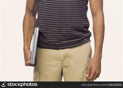 Mid section view of a mid adult man holding a laptop