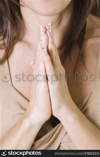 Mid section view of a mid adult woman in a prayer position