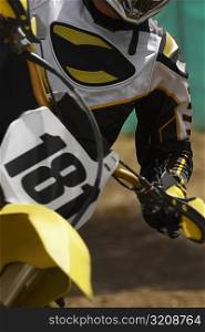 Mid section view of a motocross rider riding a motorcycle
