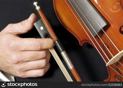 Mid section view of a musician holding a violin