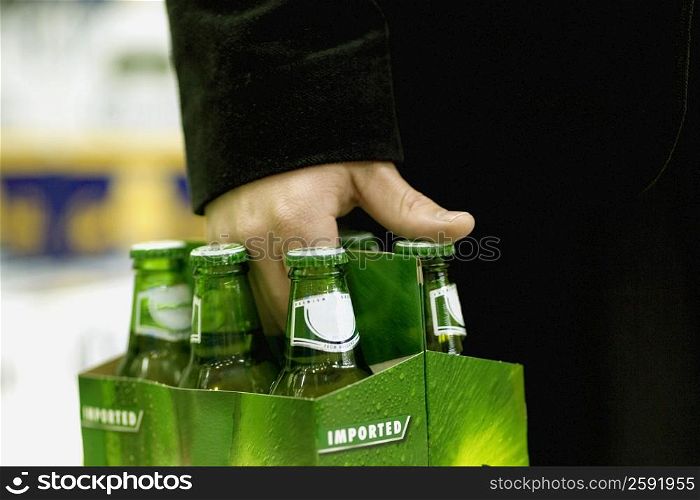 Mid section view of a person&acute;s hand carrying cold drinks