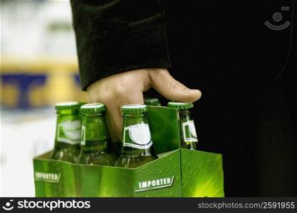 Mid section view of a person&acute;s hand carrying cold drinks