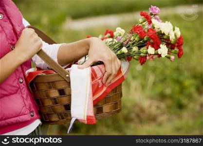 Mid section view of a person carrying a flower basket