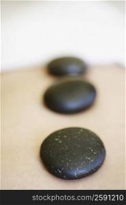 Mid section view of a person getting hot stone therapy