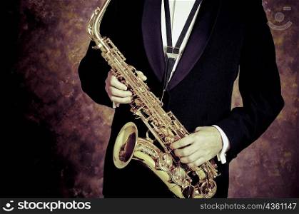 Mid section view of a person playing a saxophone