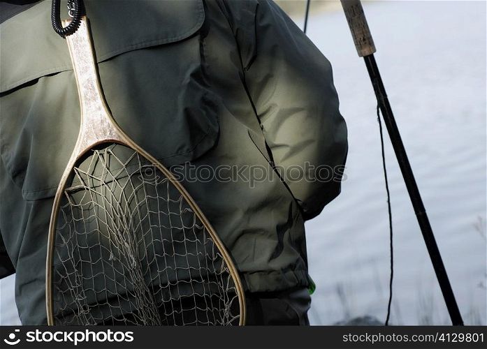 Mid section view of a person with a fishing net on his back