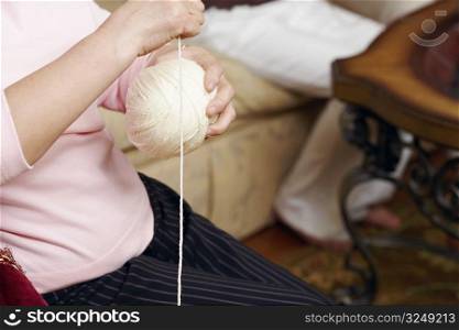 Mid section view of a senior woman holding a ball of wool