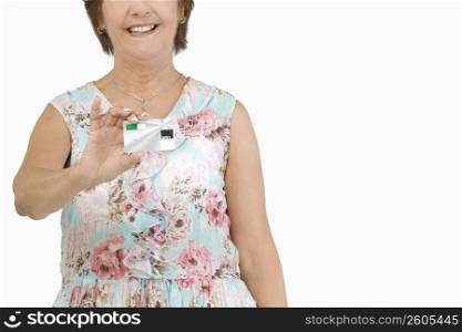 Mid section view of a senior woman holding a credit card