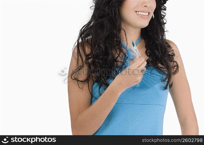 Mid section view of a teenage girl holding a credit card