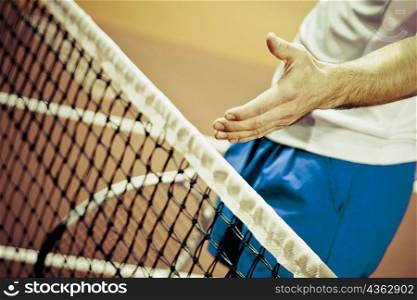 Mid section view of a tennis player stretching out his hand for handshake
