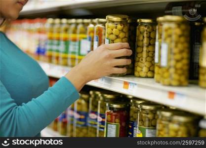 Mid section view of a woman choosing pickles