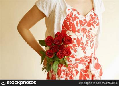 Mid section view of a woman holding a bunch of roses