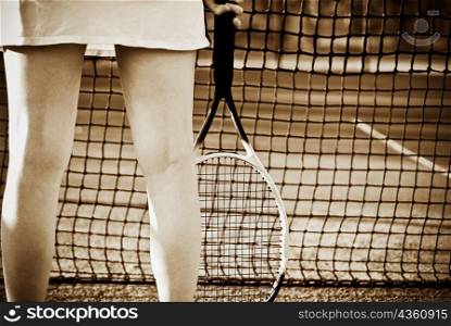 Mid section view of a woman holding a racket
