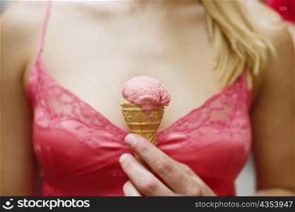 Mid section view of a woman holding an ice-cream cone