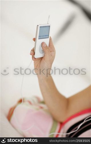 Mid section view of a woman holding an MP3 player