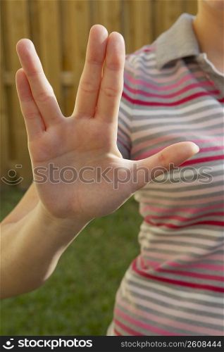 Mid section view of a woman making a hand sign