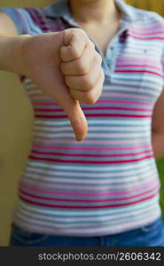 Mid section view of a woman making a thumbs down sign