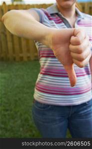 Mid section view of a woman making a thumbs down sign