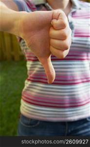 Mid section view of a woman making a thumbs down sign