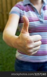 Mid section view of a woman making a thumbs up sign