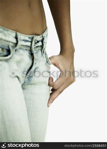 Mid section view of a woman standing with her finger in her pocket